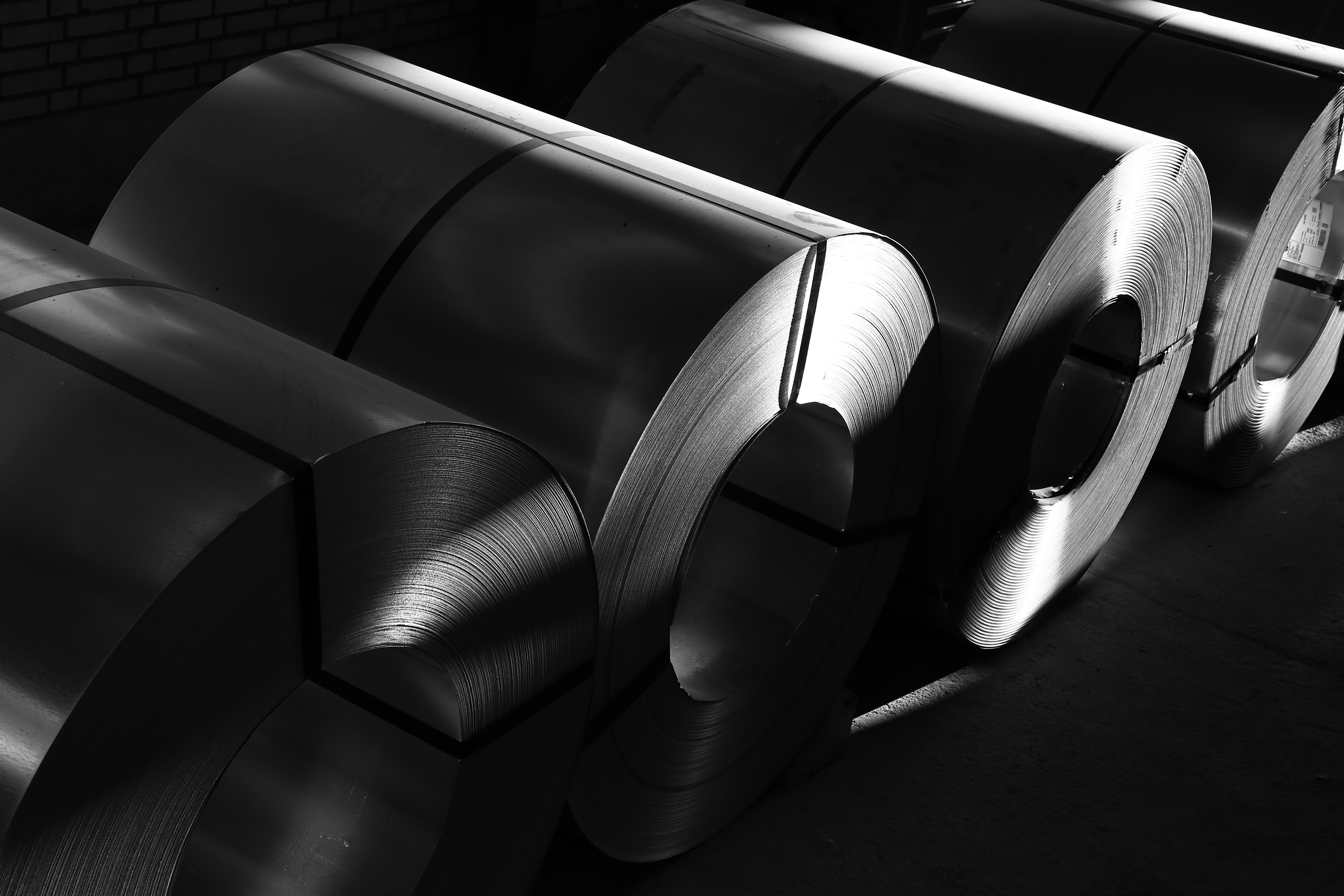 Flat metal strip and sheet material in coil form
