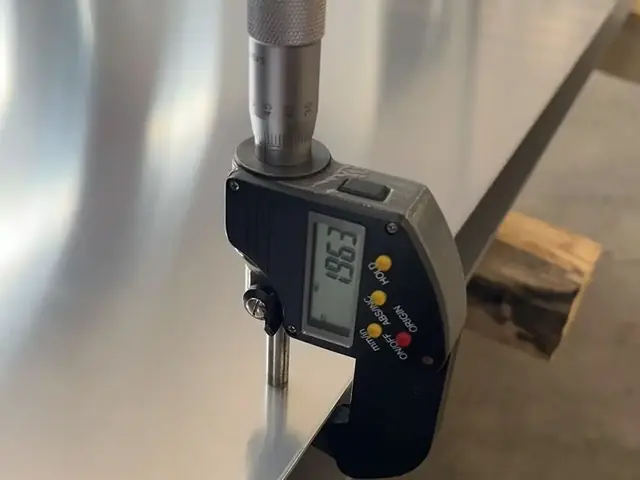 Micrometer checking nickel alloy sheet thickness